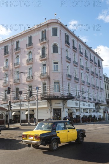 Alexandria, Egypt. December 4th 2022 Egyptian taxi passing the famous Trianon Cafe restaurant, Saad Zaghloul street, Raml Station, the Mediterranean Sea front city of Alexandria, Egypt
