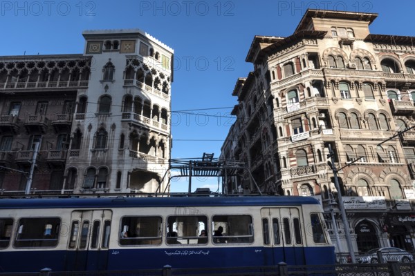 Alexandria, Egypt. December 4th 2022 Historical architecture and old tram passing in typical Alexandria street. Colonial history of Mediterranean city of Alexandria, Egypt