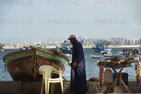 Alexandria, Egypt. December 1st 2022 An informal tourist souvenir stall beside a fishing boat on the Mediterranean seafront of Egypt's second largest city, Alexandria, Egypt