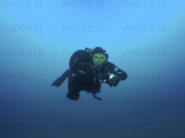 A diver in full gear floats in deep blue water. Giuseppe Dezza wreck dive site, Pula, Croatia, Mediterranean