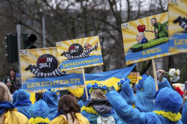 Members of the Blau-Gelbes Kreuz association, German-Ukrainian Association e.V., as a foot group at the Düsseldorf Rose Monday procession, show pictures with motifs from previous carnival motifs by the wagon manufacturer Jacques Tilly, who denounces Russia's war against Ukraine, a criminal case is therefore being brought against him in Russia, expression of solidarity for Tilly, North Rhine-Westphalia, Germany