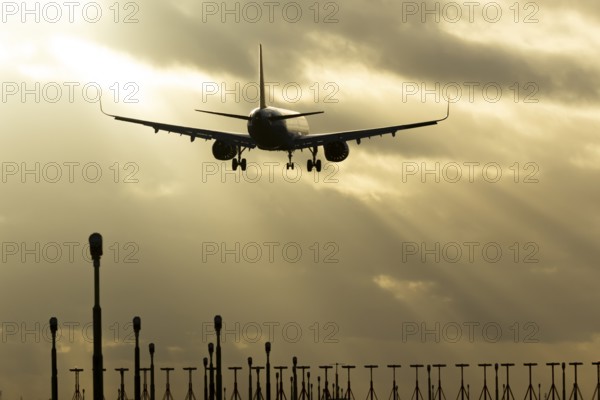 Airbus A321 commercial passenger airliner jet aircraft of Pegasus airlines flying on approach to land over runway lights at sunset at London Stansted airport, Essex, England, United Kingdom