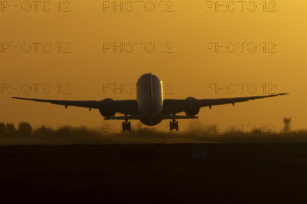 Boeing 777 A7-BFL commercial jet aircraft of Qatar cargo taking off in flight silhouette at sunset at London Stansted airport, Essex, England, United Kingdom