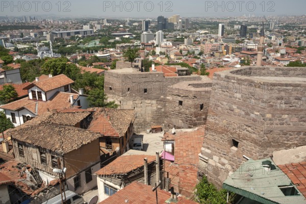 A panoramic view of old and modern houses from the ancient city walls of Ankara castle, Anatolia, Turkey. Visitors to Ankara castle enjoy a panoramic view of the modern Turkish capital from the old town city walls. Ankara, Turkey