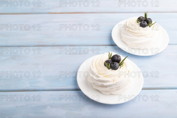Pavlova Meringue dessert with crisp meringue and blueberry on blue wooden background, copy space, side view