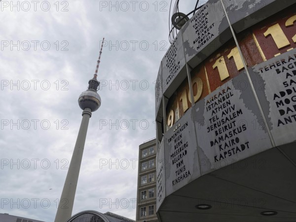 View of the Berlin TV Tower and the World Clock on Alexanderplatz under a cloudy sky, Berlin