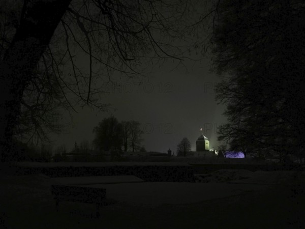 Night view of a dark landscape with a dimly lit, silhouetted Rosenberg Fortress, Kronach, Frankenwald nature park Park