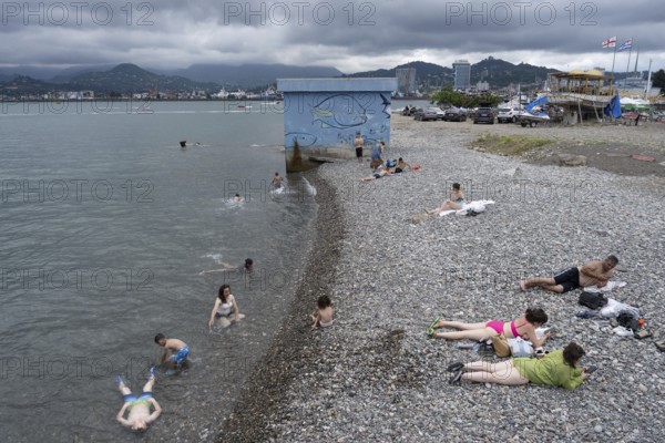 Batumi, Georgia. July 21st 2025. Georgian locals relax on the beach near Batumi Port on the Black Sea coast of Georgia