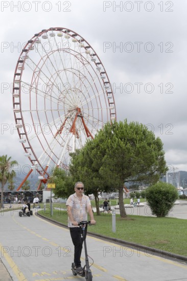 Batumi, Georgia. July 21st 2025. Visitors and tourists ride electric scooters along a dedicated bike path on the seafront at Batumi on the Black Sea coast of Georgia