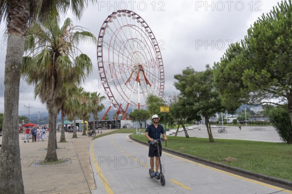 Batumi, Georgia. July 21st 2025. Visitors and tourists ride electric scooters along a dedicated bike path on the seafront at Batumi on the Black Sea coast of Georgia