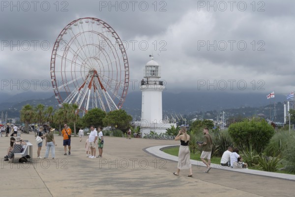 Batumi, Georgia. July 21st 2025. A light house and Ferris wheel near Batumi Port, a popular esplanade for locals and tourists beside the Black Sea coast of Georgia