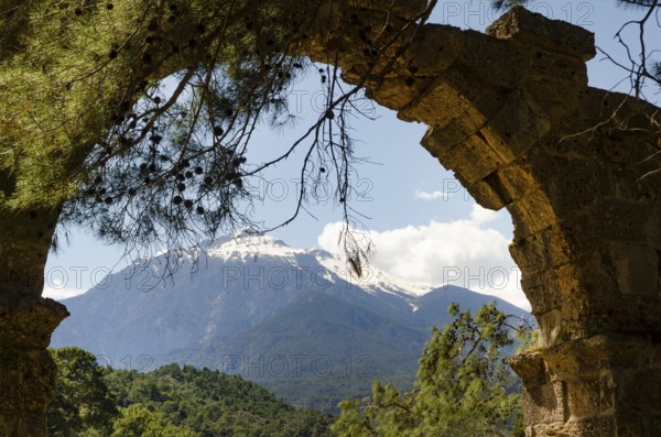 The Turkish Bey Mountains seen through the silhouette of the Phaselis Aqueduct, Kemer, Antalya, Turkey