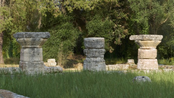Three stone column remains in a green area, Archaeological Site, Ancient Olympia, Olympia, Peloponnese, Greece