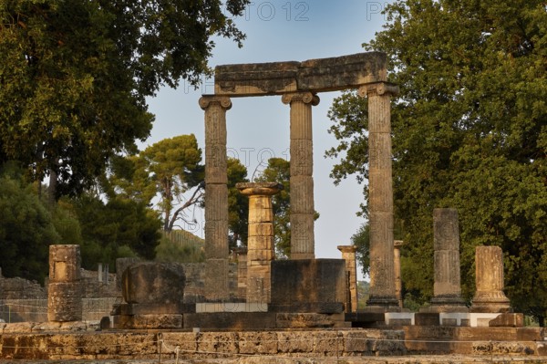 Philippeion, Sublime ancient columns in an archaeological site with trees in the background, Archaeological Site, Ancient Olympia, Olympia, Peloponnese, Greece