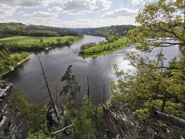 A panoramic view from the Agnesruh viewpoint on a loop of the Saale in the midst of green hills and forests under a clear sky, hiking in the Thuringian Forest nature park Park