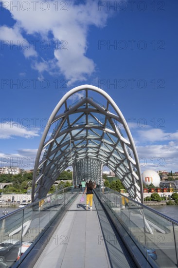Tbilisi, Georgia. September 12th 2025 Tourists cross The Bridge of Peace over the Kura River also known in Georgia as the Mtkvari River in the Georgian capital, Tbilisi, Georgia