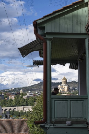 Tbilisi, Georgia. September 12th 2025 Traditional wooden balcony of a local Georgian house overlooking Tbilisi and the Holy Trinity Cathedral, Georgia