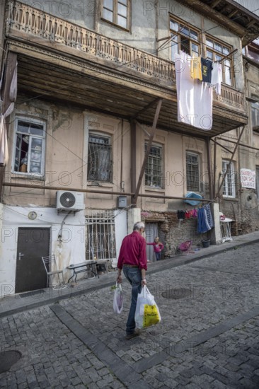 Tbilisi, Georgia. September 12th 2025 An old man walks through the cobbled narrow streets past traditional architecture of the Old Town of Tbilisi, Georgia