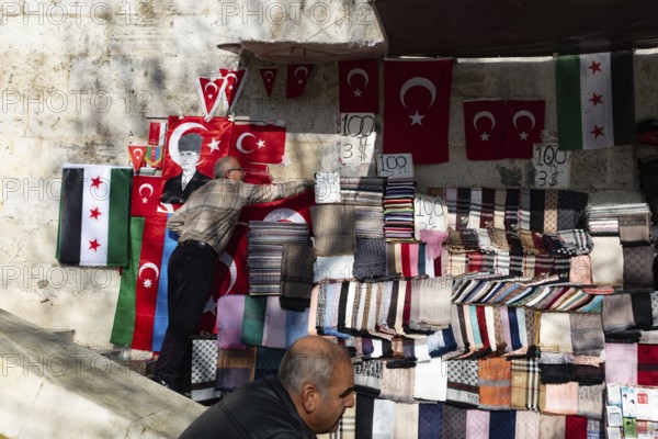 Istanbul, Turkey. January 3rd 2025. A man selling Turkish and Syrian Revolutionary flags at a street market near the Grand Bazaar, Istanbul, Turkey