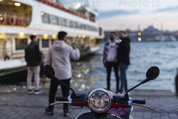 A scooter during evening time beside the Bosporus Straight at the Karakoy Ferry port near the Galata Bridge, Istanbul, Turkey