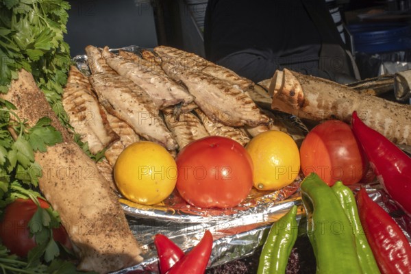 Tasty looking grilled mackerel and fresh vegetables ready to prepare Balik Ekmek, a traditional Turkish street food translating as fish and bread, Karakoy Fish Market, Istanbul, Turkey