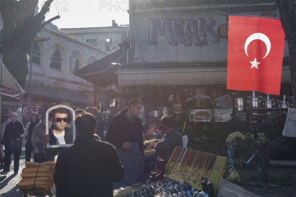 Istanbul, Turkey. January 3rd 2025. A man trying a pair sunglasses in a busy shopping bazaar in the crowded Eminonu district near the Spice Bazaar, Istanbul, Turkey