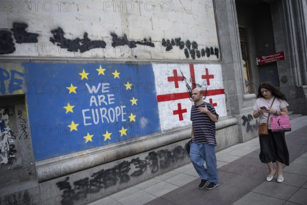 Tbilisi, Georgia. August 26th 2025. Georgian people walk past the flags of Georgia and the European Union along Shota Rustaveli Avenue near to Freedom Square, in central Tbilisi, Georgia