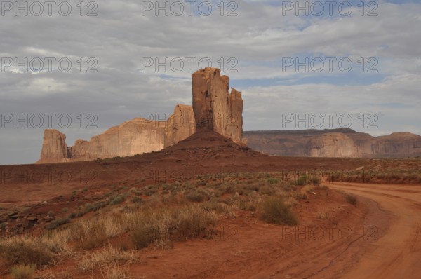 Distinctive tall rock rises in a barren, red desert landscape after a severe thunderstorm, Monument Valley, Navajo Tribal Park, Navajo Nation Reservation, Utah, Arizona, USA