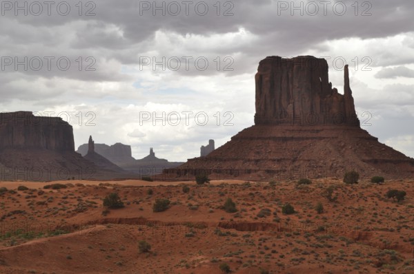 Dramatic view of a large rock formation under a cloudy sky in Monument Valley, Navajo Tribal Park, Navajo Nation Reservation, Utah, Arizona, USA
