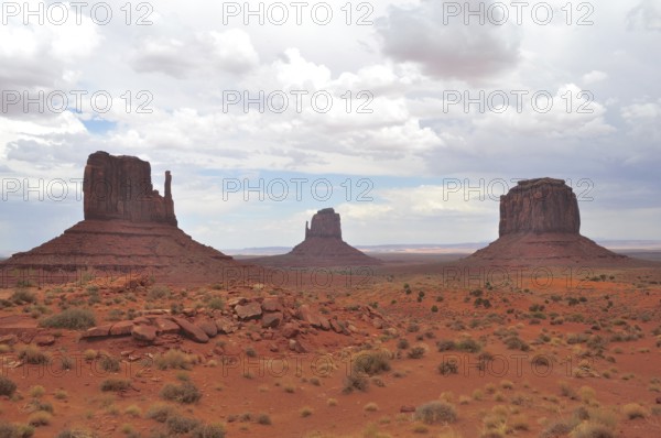 Monument Valley with distinctive rock formations and sparse vegetation under cloudy sky, Monument Valley, Navajo Tribal Park, Navajo Nation Reservation, Utah, Arizona, USA