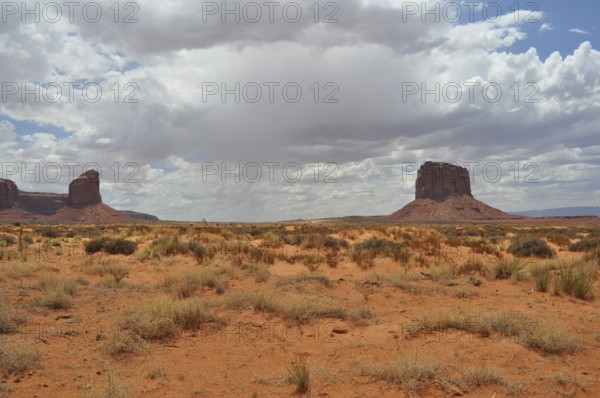 Wide dry plain with isolated rocks under dramatic skies, Monument Valley, Navajo Tribal Park, Navajo Nation Reservation, Utah, Arizona, USA