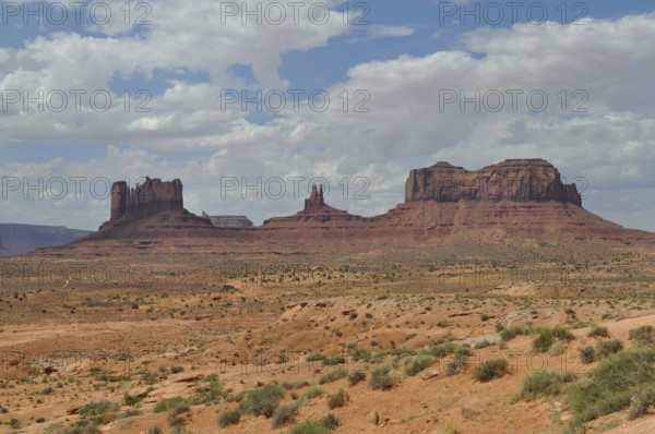Impressive rock formations rise in a sunny desert landscape, Monument Valley, Navajo Tribal Park, Navajo Nation Reservation, Utah, Arizona, USA
