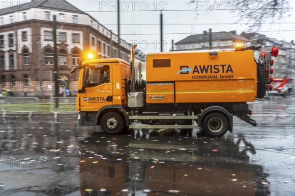 Sweeping on Rose Monday in Düsseldorf, the municipal utilities clean up after the train, confetti, camels, trash, employees with sweepers from AWISTA, Society for Waste Management and City Cleaning, central disposal and urban cleaning companies in Düsseldorf, clean the train's path with their street cleaning machines, North Rhine-Westphalia, Germany