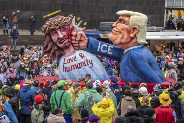 Rose Monday procession in Düsseldorf, theme car by wagon manufacturer Jacques Tilly, theme US President Donald Trump beats Jesus, ICE logo on his sleeve, against the domestic politics of the US government of North Rhine-Westphalia, Germany