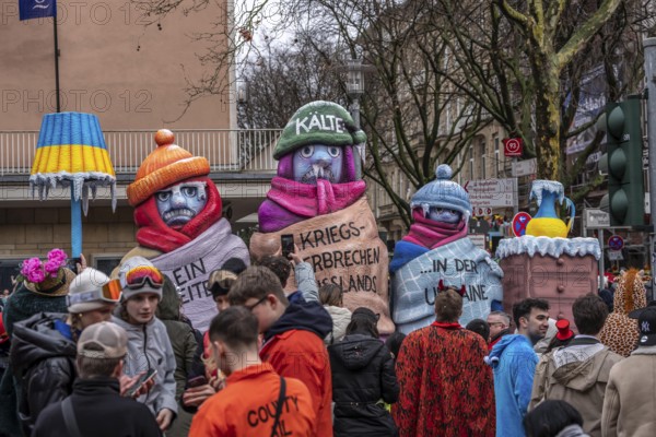 Rose Monday procession in Düsseldorf, theme car by wagon manufacturer Jacques Tilly, topic of suffering population in Ukraine due to Russia's war of aggression, destruction of energy supply infrastructure, freezing people in freezing cold weather, North Rhine-Westphalia, Germany