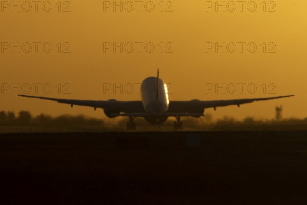 Boeing 777 A7-BFL commercial jet aircraft of Qatar cargo taking off in flight silhouette at sunset at London Stansted airport, Essex, England, United Kingdom