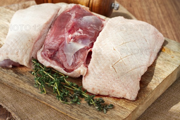 Fresh raw duck breast, on a wooden chopping board, top view, no people