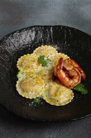 Ravioli with shrimp, in cream sauce, with spices and herbs, top view, no people