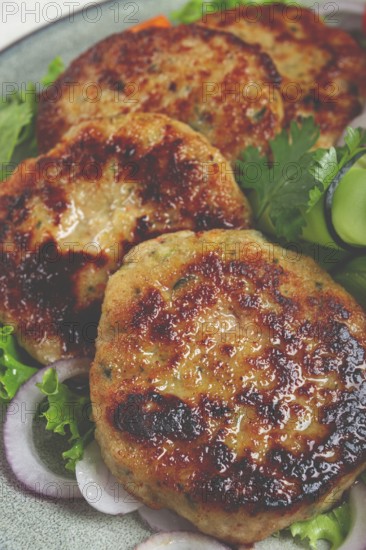 Fried chicken cutlets, minced chicken, with vegetables, on gray, with vegetable salad, top view, homemade, no people
