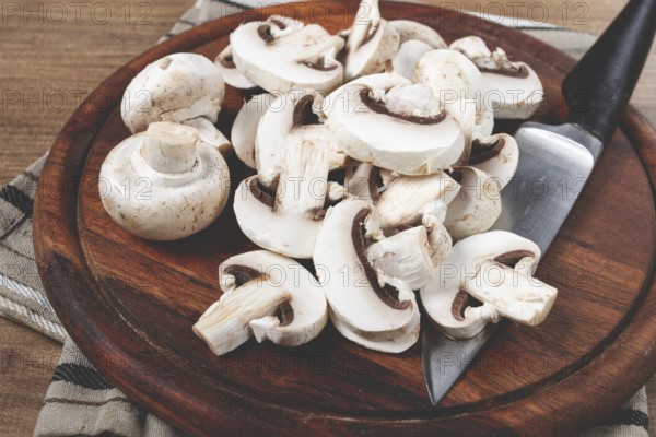 Fresh mushrooms, chopped, in a wooden bowl, whole, top view, no people