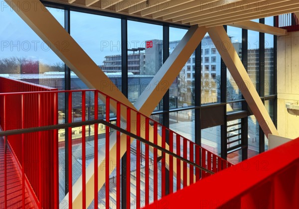 Staircase with signal red color scheme in seminar building H of Bochum University in the evening with a view of the main building, North Rhine-Westphalia, Germany