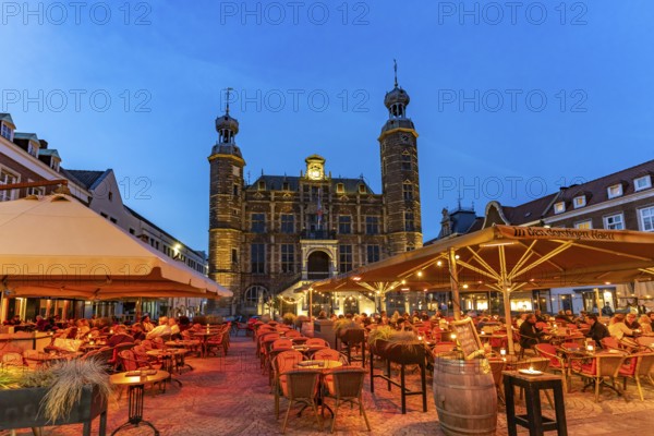 Restaurant and the historic town hall on the market in Venlo at dusk, the Netherlands