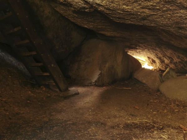 Interior view of a rocky cave, Girgel cave with wooden stairs and light at the end, Franconian mountain trail, hiking in the Fichtelgebirge nature park Park