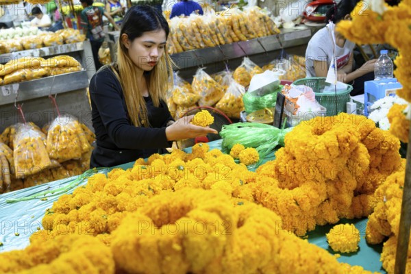 Bangkok, Thailand. March 2rd 2025. A Thai woman making traditional flower garlands at Pak khlong Talat, a Bangkok flower market