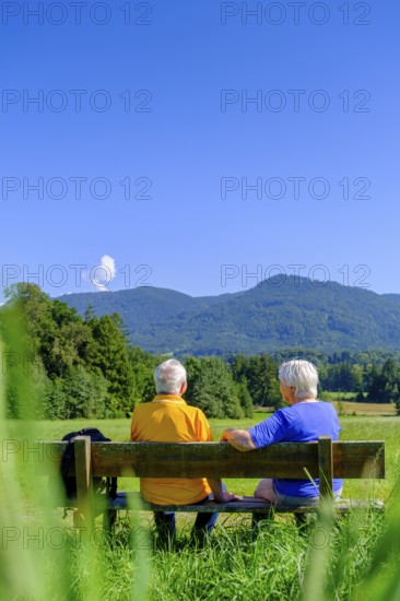 Elderly couple, seniors sitting on a rest bench, Bad Heilbrunn, Upper Bavaria, Bavaria, Germany