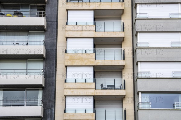 Facades of residential buildings on Zeedijk-Knokke, beach promenade in Knokke-Heist, largely uninhabited in winter, on the North Sea beach, dreary winter day, mostly apartment buildings with rental or condominiums, high-rise buildings on the street, Belgium
