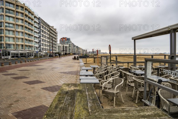 Winter break, closed terraces of catering establishments on Zeedijk-Knokke, beach promenade in Knokke-Heist, on the North Sea beach, dreary winter day, mostly apartment buildings with rental or condominiums, high-rise buildings on the street, Belgium