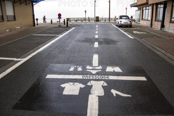 Winter break, on the Zeedijk-Knokke, beach promenade in Knokke-Heist, commandment sign, prohibition sign, for the dress code on the North Sea beach and in the city, painted on the road surface, dreary winter day, Belgium