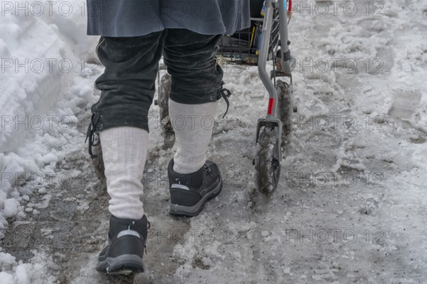 Detail, elderly man pushes his walker through slush in the city, Nuremberg, Middle Franconia, Bavaria Germany