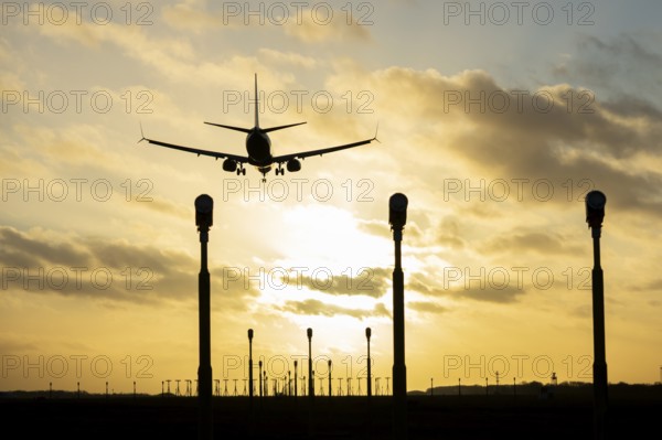 Boeing 737 commercial passenger airliner jet aircraft of Ryanair airways in flight on approach to land over runway lights at sunset at London Stansted airport, Essex, England, United Kingdom